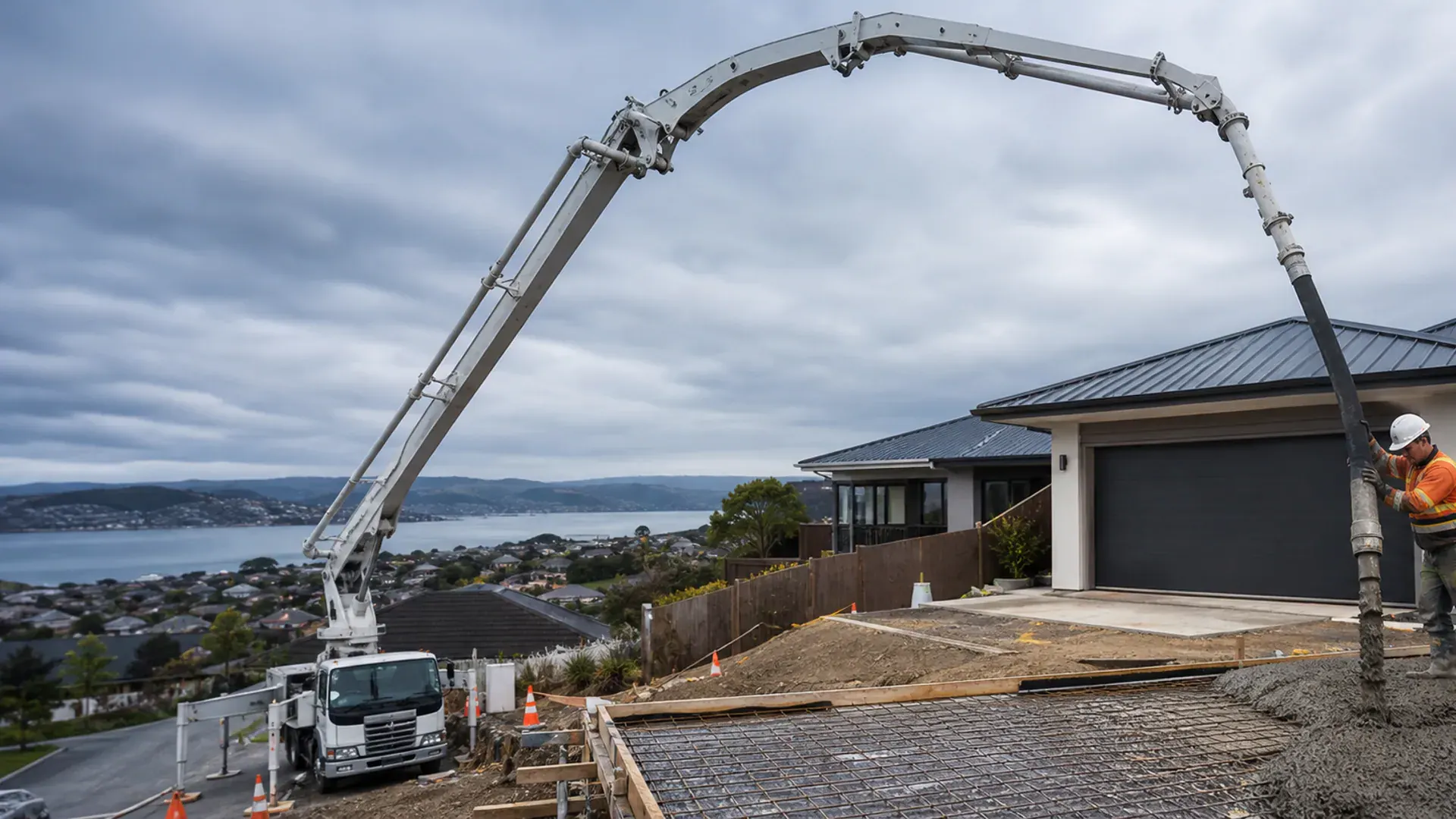 Concrete boom pump reaching a difficult-access Dunedin hillside project